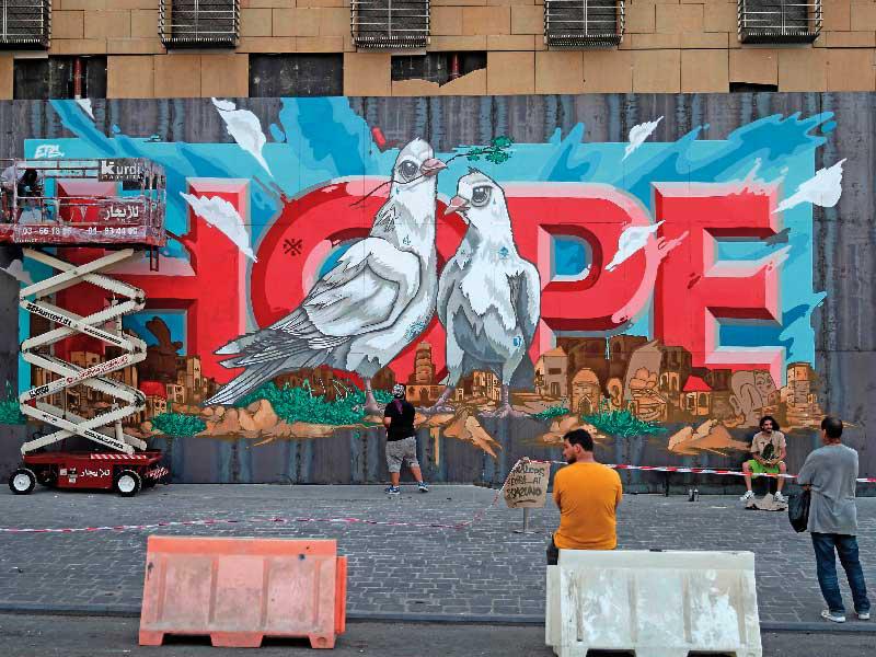 لبنانيون أمام جدارية على فندق «لوغراي» في بيروت بعنوان «الأمل»t  (أ ف ب)