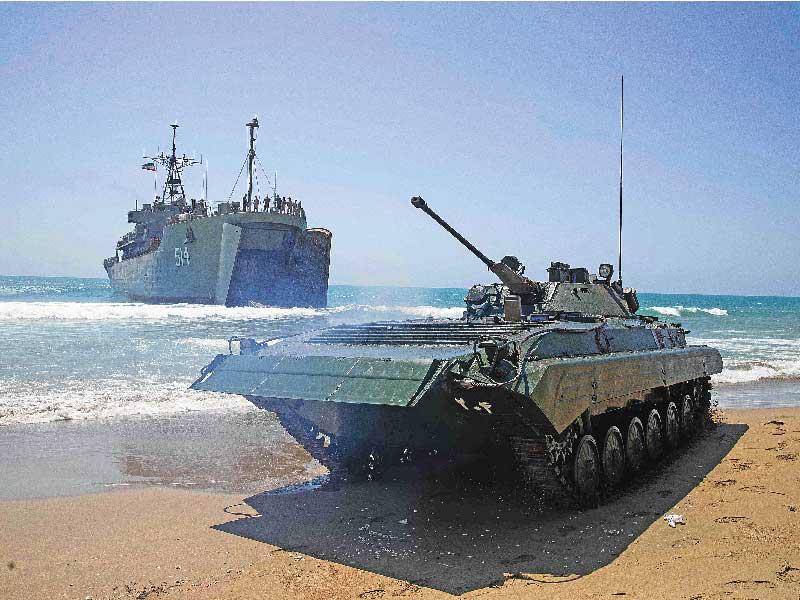 إنزال دبابة إيرانية على الشاطئ قرب هرمز أمس (رويترز)