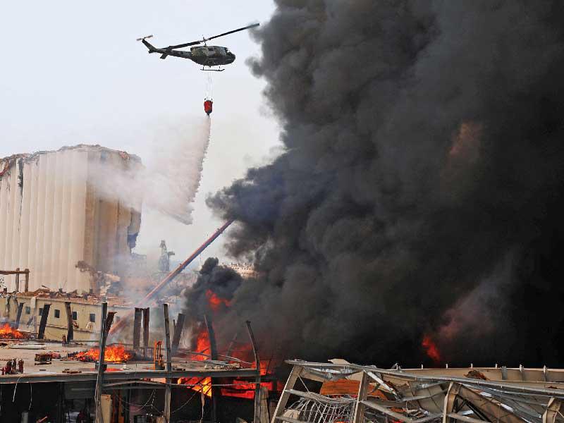 دخان الحريق يتصاعد من مرفأ بيروت أمس (رويترز)