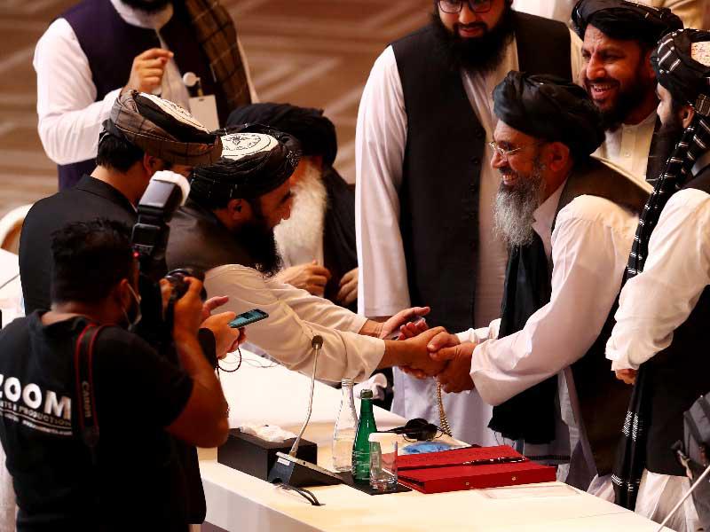 مصافحة بين عناصر وفد «طالبان» قبيل انطلاق المباحثات في الدوحة أمسt (أ ف ب)