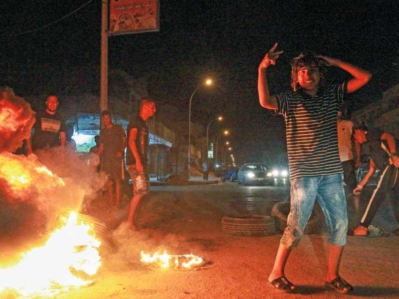 إغلاق طريق بإطارات محترقة في بنغازي أمس الأول (أ ف ب)