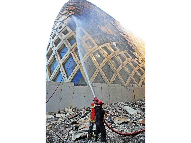 إخماد الحريق في المبنى الذي صممته المهندسة المعمارية العراقية الراحلة زها حديد في وسط بيروت أمس (ا ف ب)