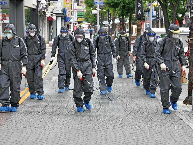 تعقيم أحد الطرق في منطقة أينشيون بكوريا الجنوبية أمس (ا ف ب)