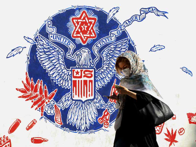 إيرانية تمر أمام جدارية معادية لواشنطن وإسرائيل في طهران أمس (أ ف ب)