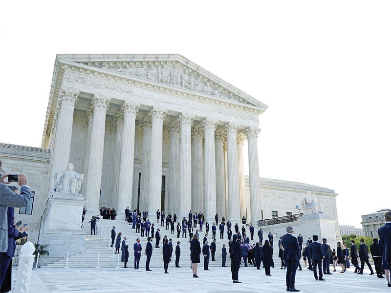 قضاة يقفون على أدراج المحكمة العليا في واشنطن أثماء وصول نعش غينسبورغ أمس (رويترز)