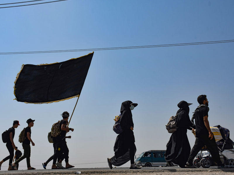 زوار شيعة يسيرون إلى كربلاء لإحياء ذكرى أربعين الحسين (أ ف ب)