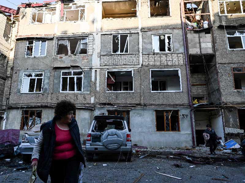 سيدة أمام مبنى في متضرر بفعل القصف في ستيباناكيرت أمسt (أ ف ب)