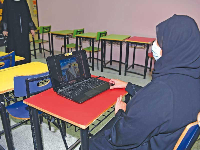 معلمة تؤدي حصتها وتظهر صورة سمو الأمير تزين الشاشة (تصوير عوض التعمري)