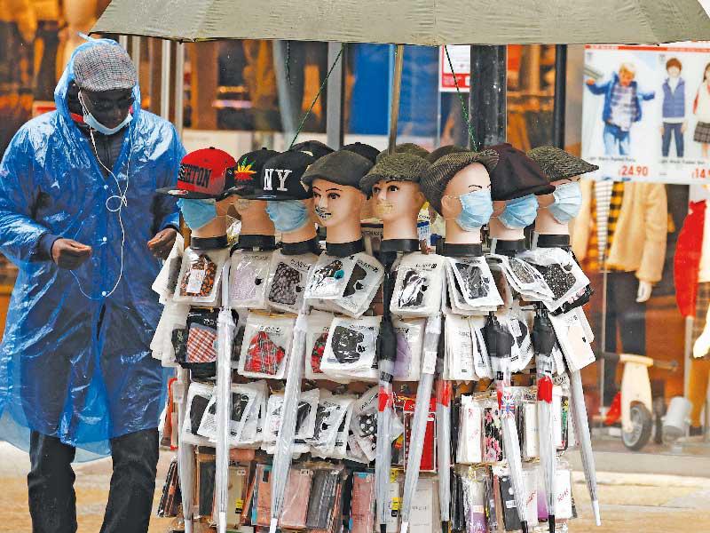 رجل يعرض كمامات للبيع في مدينة مانشستر البريطانية أمس  (رويترز)