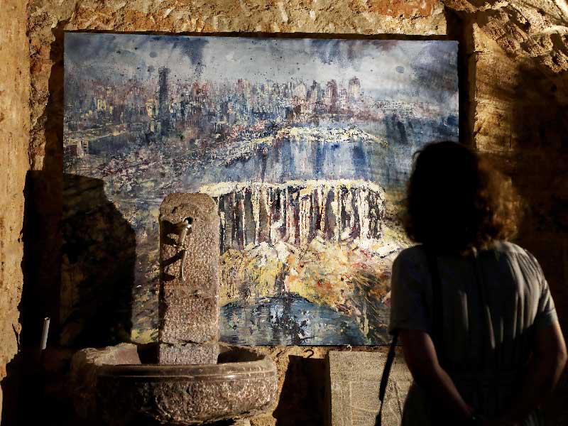 لوحة عن دمار مرفأ بيروت للرسام البريطاني توم يونغ في معرض خيري بالعاصمة اللبنانية (رويترز)