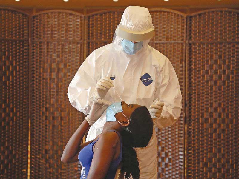 عامل صحي يجري فحصاً لـ«كورونا» لإحدى العاملات الأجنبيات قبل مغادرتها بيروت   (رويترز)