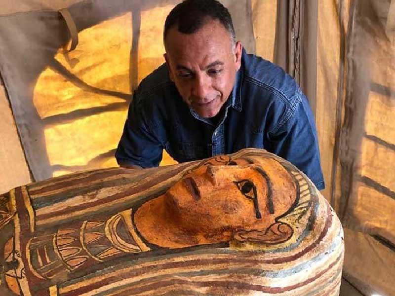 مصطفى وزيري يتفقد تابوتاً خشبياً عليه نقوش ملونة