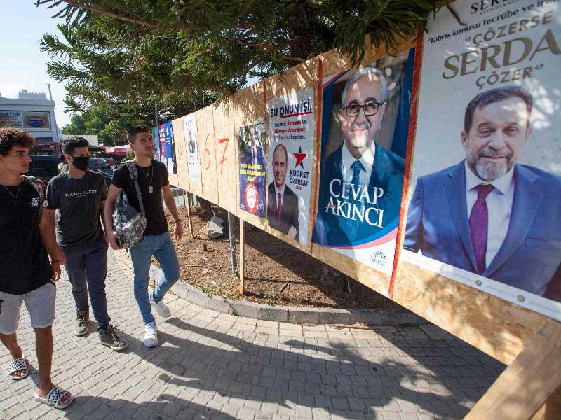 القبارصة الشباب يمرون أمام ملصقات لمرشحين للرئاسة في كيرينيا