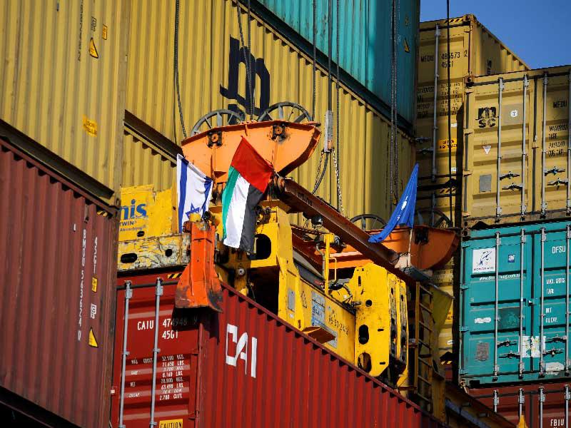 مستوعب عليه العلمان الإماراتي والإسرائيلي خلال إنزاله في مرفأ حيفا أمس   (رويترز)