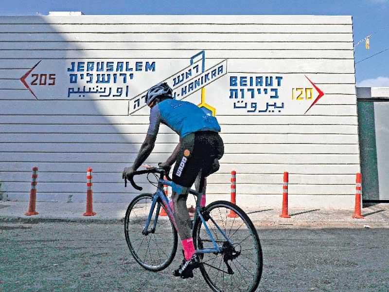 راكب دراجة إسرائيلي في الجانب الإسرائيلي من الحدود مع لبنان عند رأس الناقورة ( أ ف ب )