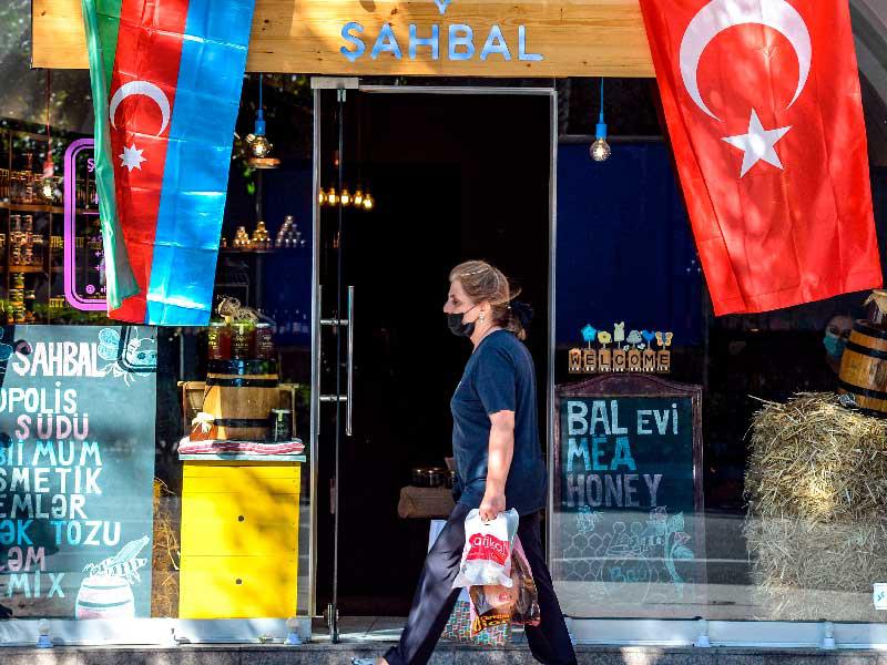 سيدة تمرّ قرب العلمين التركي والأذربيجاني في باكو أمس t(أ ف ب)