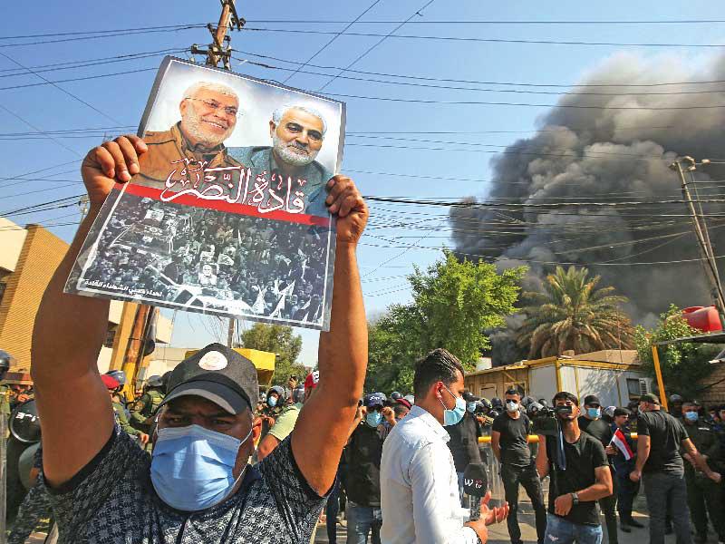 الدخان يتصاعد من مقر الحزب الديمقراطي الكردستاني بعد اقتحامه وإحراقه من أنصار «الحشد» في بغداد أمس (أ ف ب)