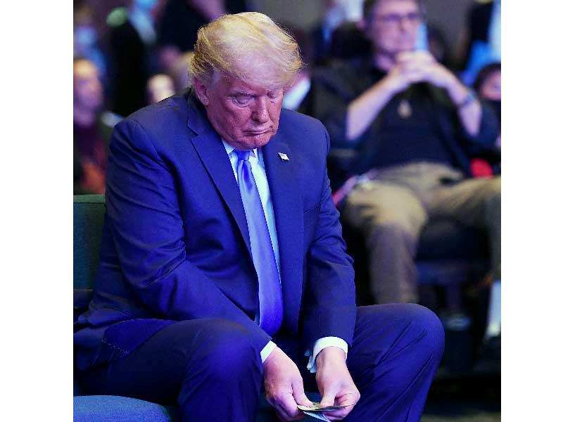 ترامب يعد الدولارات قبل تبرعه في الكنيسة أمس الأول    (أ ف ب)