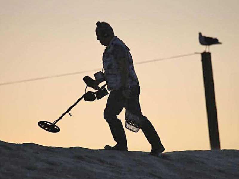 أميركي يسير خلف جهاز كشف المعادن 