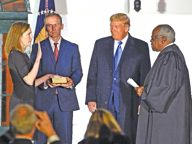 ترامب يشهد أداء باريت اليمين أمام قاضي المحكمة العليا كلارنس توماس أمس الأول (أ ف ب)