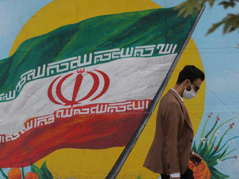 إيراني يمر أمام جدارية في طهران  (رويترز)