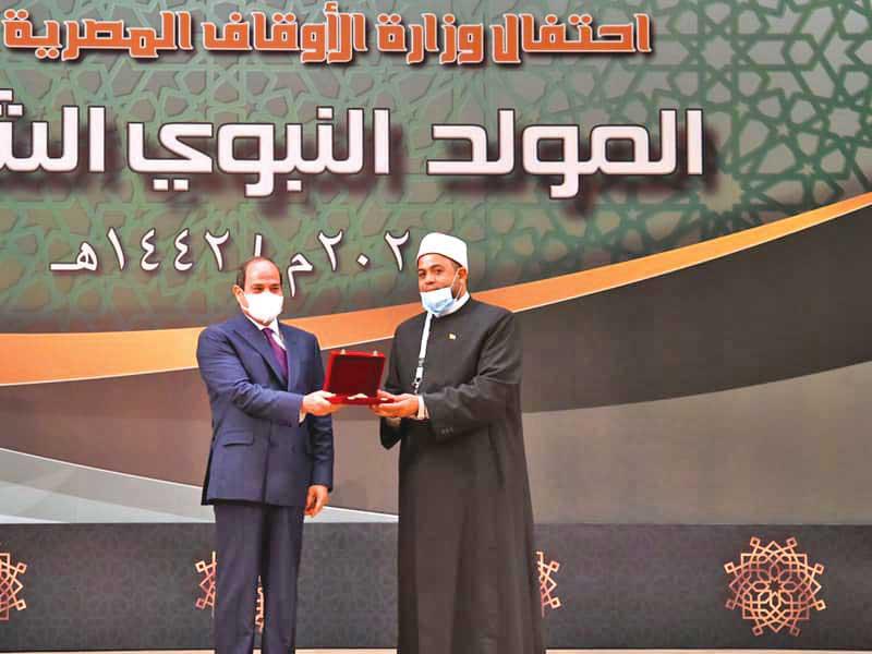 الرئيس المصري عبدالفتاح السيسي مكرماً أحد رجال الدين بمناسبة المولد النبوي في القاهرة أمس (رئاسة الجمهورية)