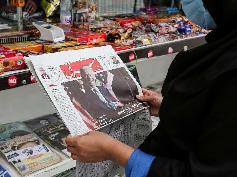مواطنة إيرانية تتصفح خبر فوز جو بايدن