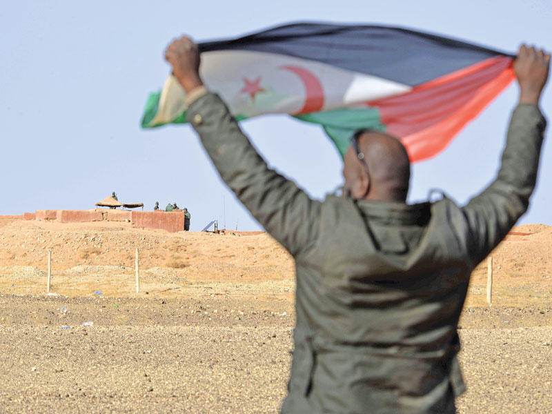 مؤيد للبوليساريو يرفع علمها مقابل مركز عسكري مغربي (أ ف ب)