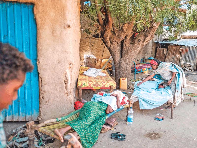 إثيوبية تداوي ابنتها التي أصيبت جراء اشتباكات في منطقة حميرة قرب تيغراي أمس الأول t(أ ف ب)