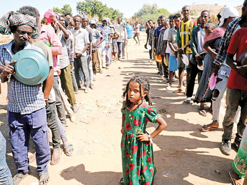 إثيوبيون يصطفون للحصول على وجبات داخل مخيم «الركوب» السوداني أمس الأول (رويترز)