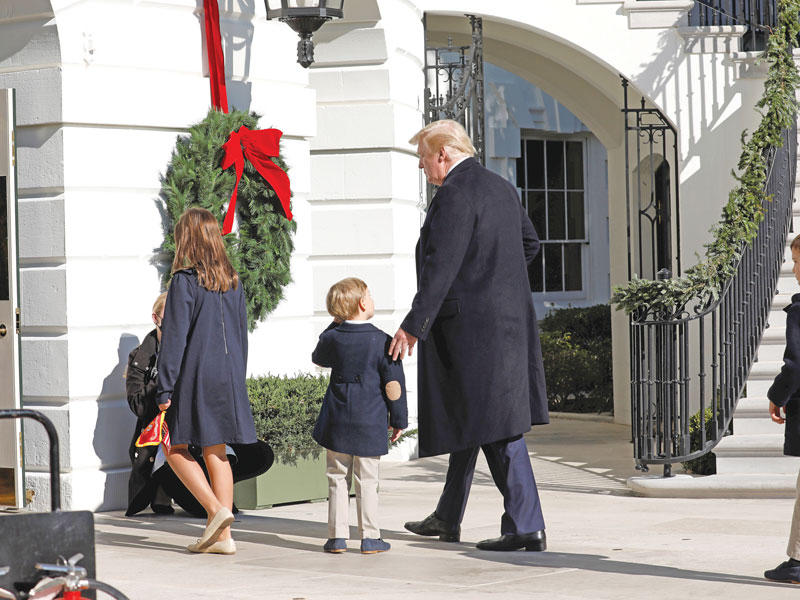 دونالد ترامب في طريقه إلى البيت الأبيض مع أحفاده أرابيلا وجوزف وثيودور كوشنير بعد عودته من كامب دايفيد أمس الأول (ا ف ب)