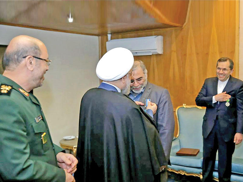 صورة نشرتها وكالة «إرنا» الرسمية الإيرانية أمس لروحاني مقلداً فخري زاده وساماً بسبب دوره في المفاوضات النووية 