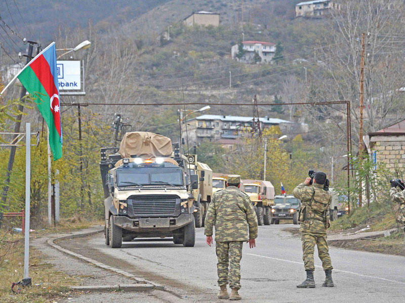 جنزد أذربيجانيون يصوّرون دخول آليات عسكرية إلى إقليم لاتشين أمس (ا ف ب)