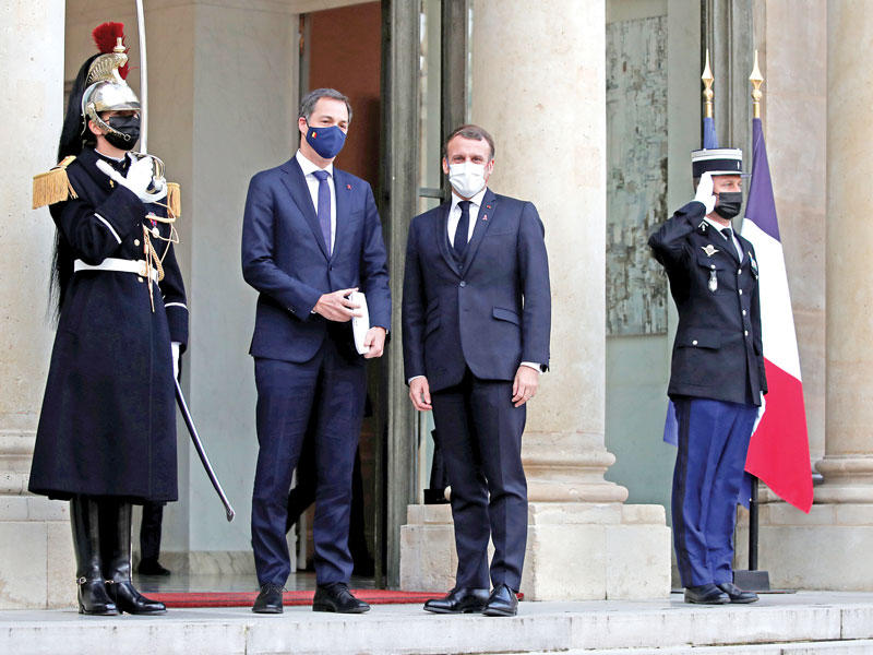 الرئيس الفرنسي إيمانويل مستقبلاً رئيس وزراء بلجيكا ألكسندر دو كروو على مدخل «الإليزيه» أمس (رويترز)