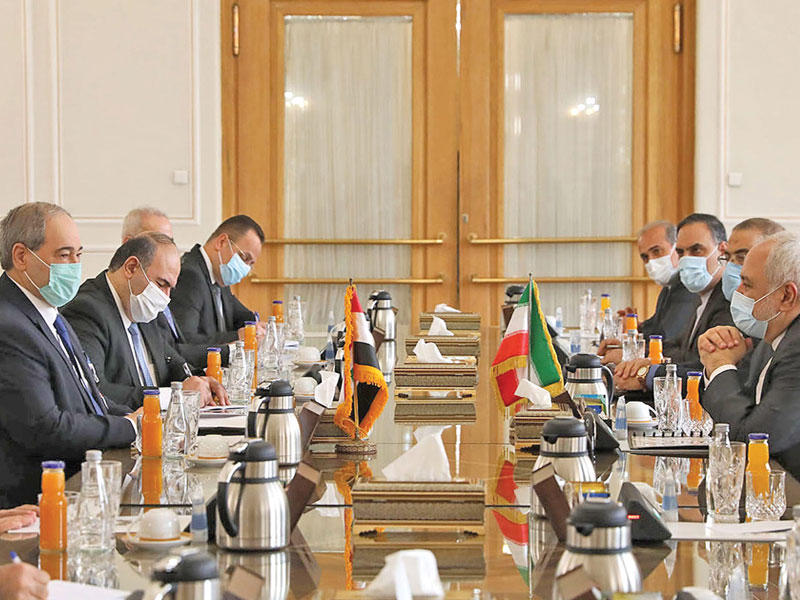 وزير الخارجية الإيراني محمد جواد ظريف مجتمعاً بوزير خارجية سورية فيصل المقداد والفريق المرافق له في طهران أمس الأول       (أ ف ب)