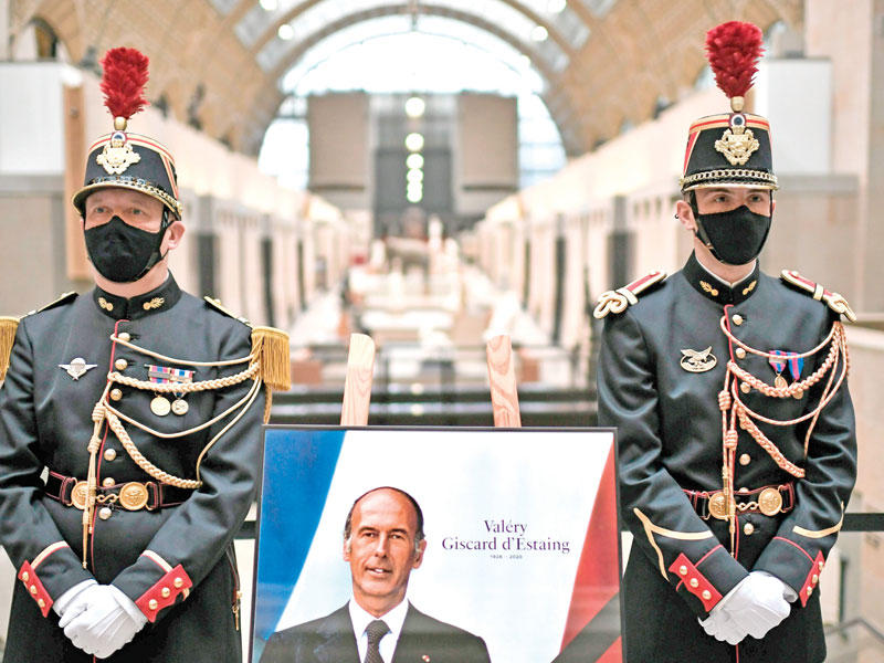 جنديان يحرسان صورة للرئيس الفرنسي الراحل فاليري جيسكار ديستان    (رويترز)