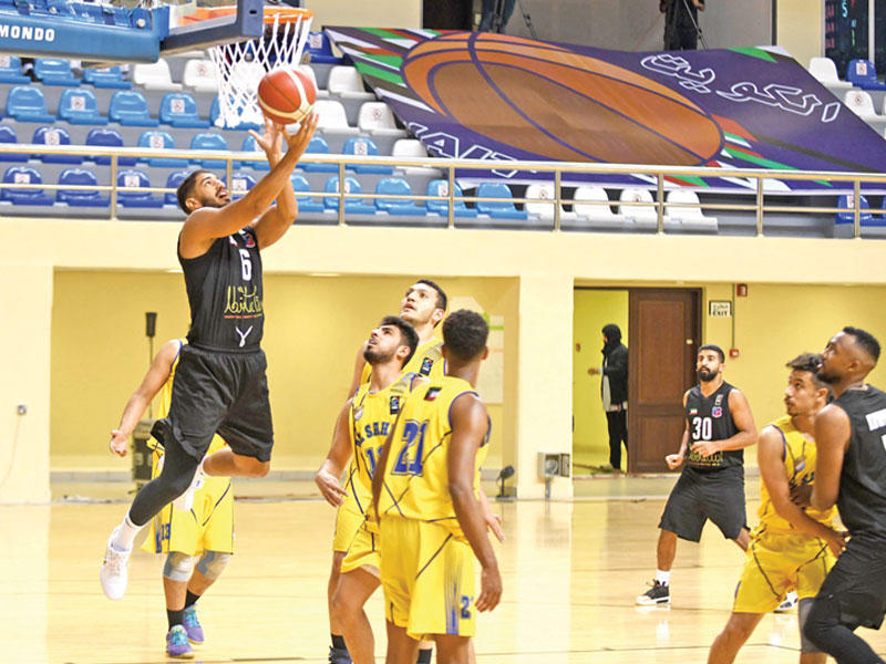 حسين الخباز لاعب الكويت يسجل في سلة الساحل