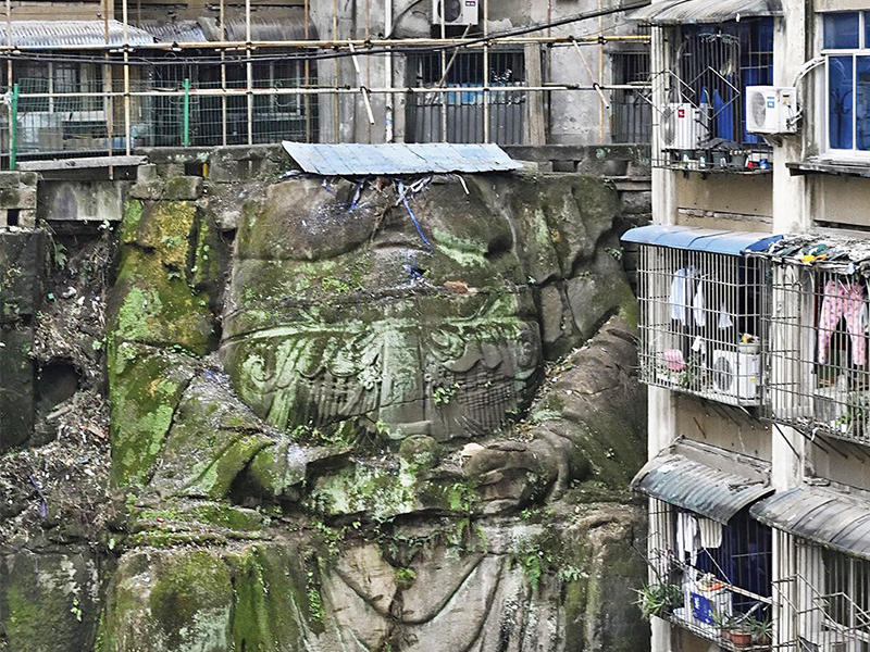 تمثال ضخم لبوذا مقطوع الرأس يدعم مبنى سكنياً في مدينة تشونغتشينغ جنوب غرب الصين