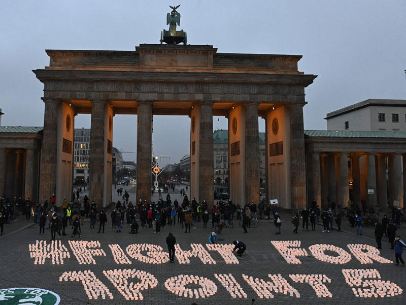 نشطاء مؤيدون لحماية المناخ وضعوا على الأرض عبارة بالشموع أمام بوابة براندنبورغ التاريخية في برلين أمس الأول (ا ف ب)