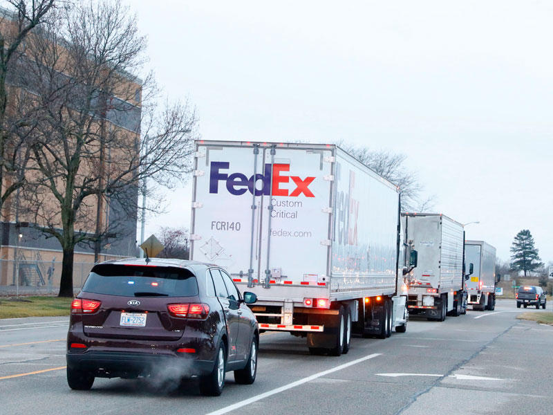  شاحنات مبرّدة تنقل لقاح «فايزر» بمرافقة أمنية في ولاية ميشيغان أمس (ا ف ب)