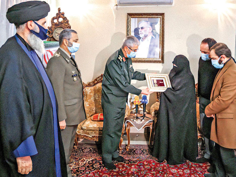 رئيس أركان الجيش الإيراني محمد باقري يسلم إلى زوجة العالم النووي محسن فخري زاده وساماً عسكرياً خلال زيارة قام بها لمنزل الأسرة في طهران أمس   (أ ف ب)
