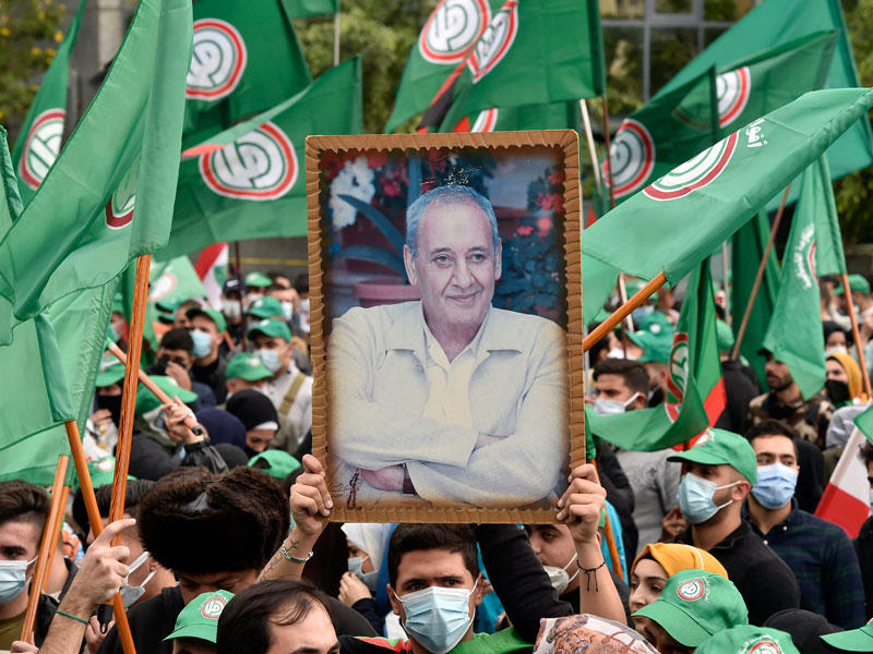 طلاب مؤيدون لحركة أمل يرفعون صورة رئيس البرلمان نبيه برّي خلال تظاهرة احتجاجية على رفع رسوم أقساط الجامعات في بيروت أمس (اي بي اي)