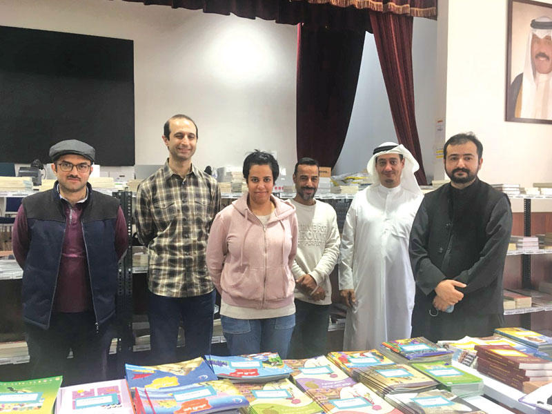 مسؤول معرض الكتاب الافتراضي لدى مؤسسة الكويت للتقدم العلمي محمد الحسن مع مجموعة من العاملين في المعرض 