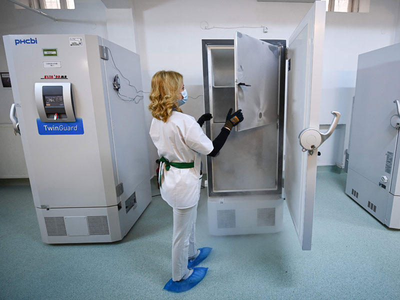 ممرضة رومانية تتفقد ثلاجات لقاح فايزر في المخزن الوطني للقاحات في بوخارست (أ ف ب )