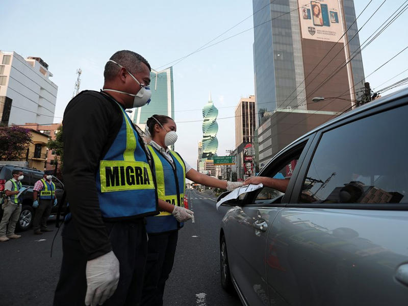 رجال شرطة يفحصون وثائق سائقي السيارات أثناء حظر التجول مع استمرار تفشي مرض فيروس كورونا في بنما (رويترز - أرشيفية)