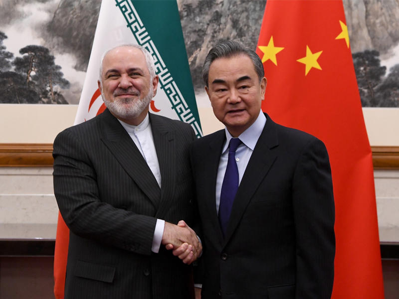 وزير الخارجية الإيراني محمد جواد ظريف يصافح وزير الخارجية الصيني وانغ يي في بكين في 31 ديسمبر 2019 (AFP)