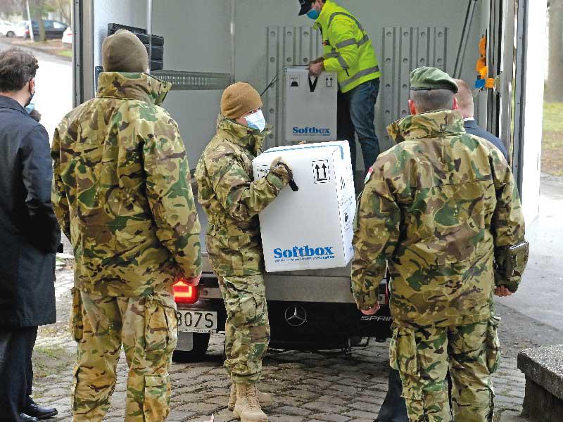 جنود ينقلون عبوات لقاح «فايزر» إلى أحد المستشفيات في بودابست أمس    (إي بي اي)