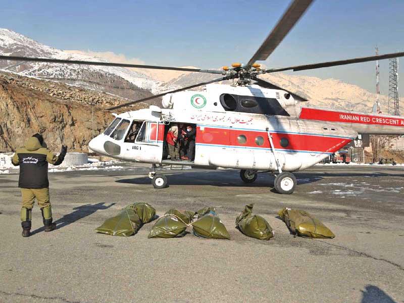 جثث ضحايا الانهيار الثلجي أمام مروحية تابعة لجمعية الهلال الاحمر شاركت في عمليات الإنقاذt(أي بي ايه) 