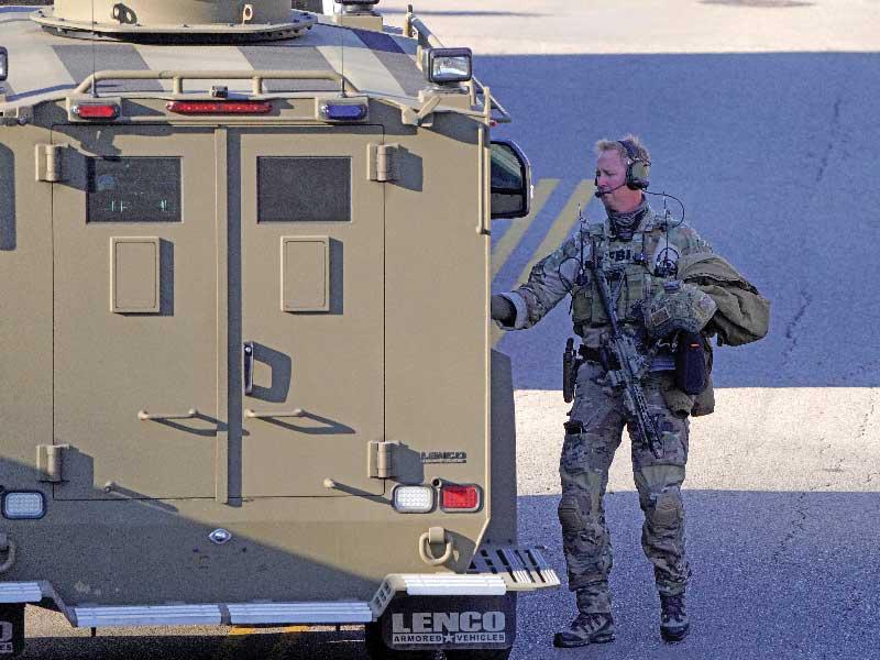 عنصر أمني خلال مداهمة أحد المنازل في تينيسي أمس الأول (رويترز)