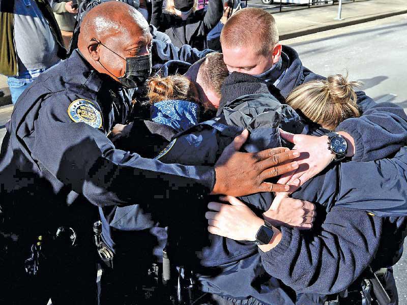رئيس شرطة ناشفيل مترو جون دريك يحتضن ضباطه بعد مؤتمرهم الصحافي أمس الأول (رويترز)